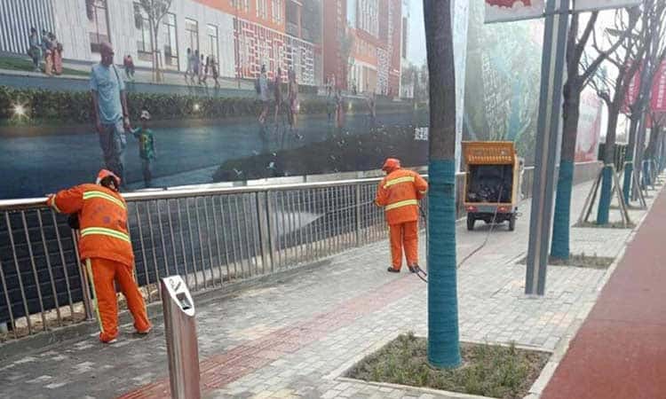 Pressure washer truck cleaning small streets
