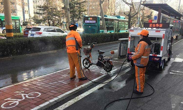 Pressure washer truck sweeps narrow streets