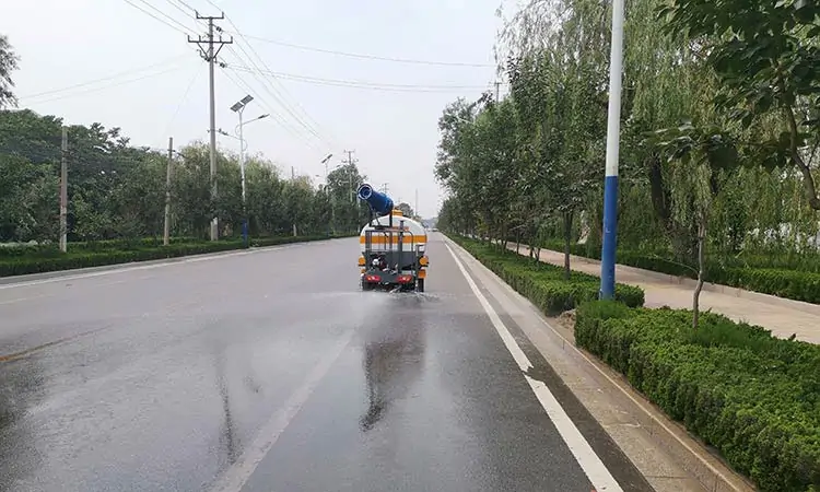 Three-wheeled sprinkler truck sprinkles water on the road