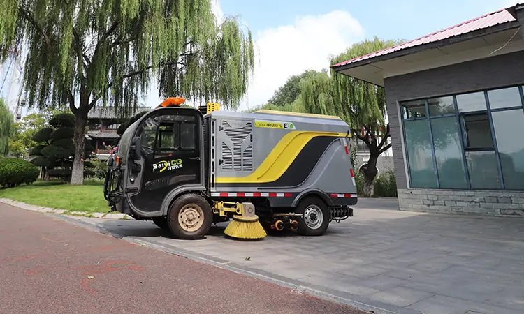 A Small Electric Street Sweeper Is Used For Cleaning And Maintenance In A Park
